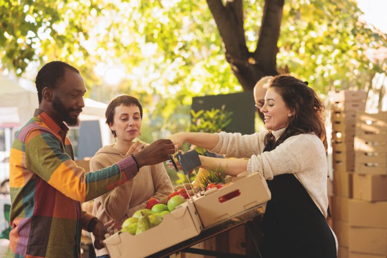 Das Foto zeigt eine Markt Situation, in der Kunden Obst bei Obsthändlern kaufen.