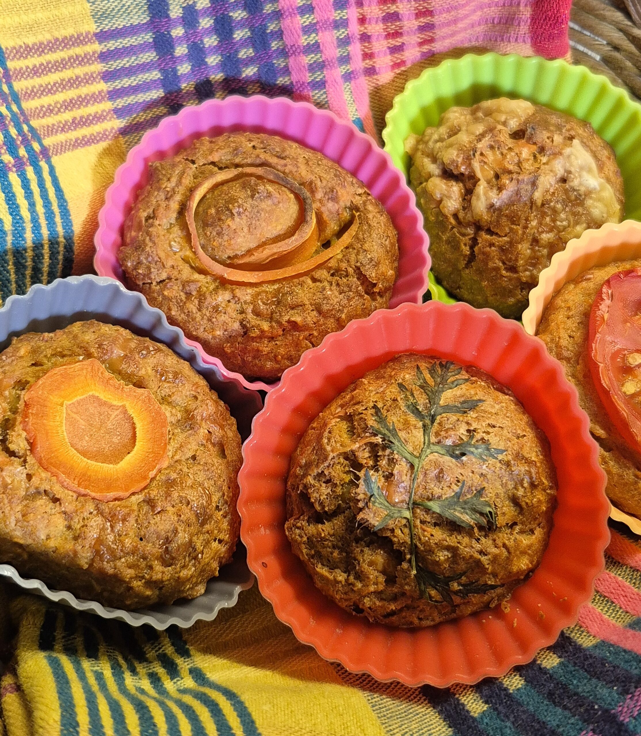 Das Foto zeigt fünf verschiedene Gemüse Muffins in bunten Muffin Schälchen.