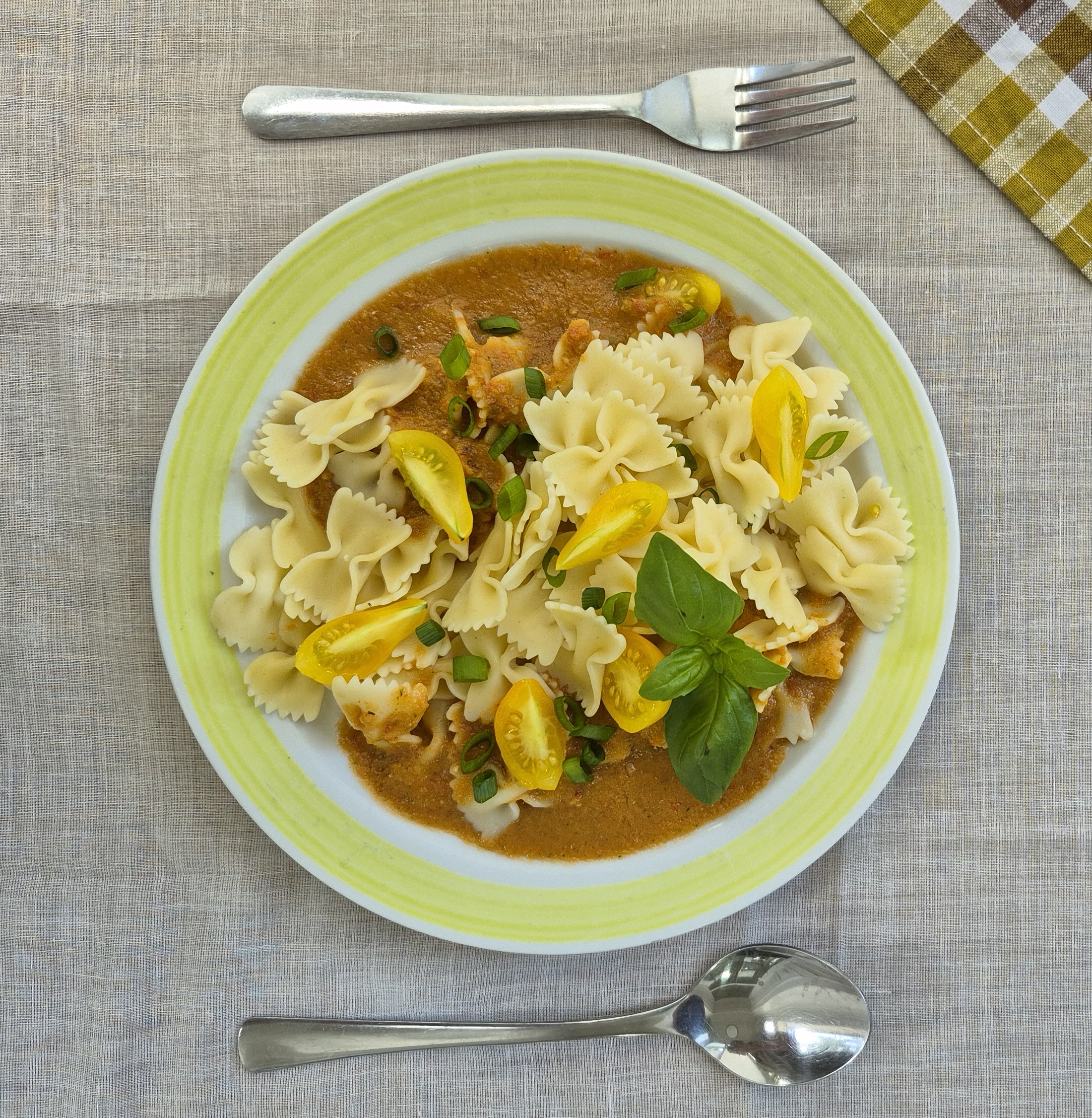 Das Foto zeigt Pasta mit roter Soße und Tomaten.